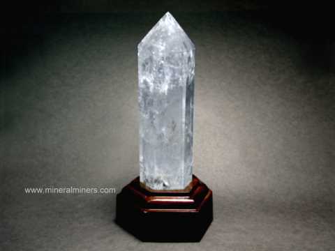 link to page displaying polished crystals of <em>ALL</em> Minerals (shown is a large polished quartz crystal with wood stand)
